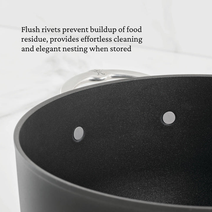 A close-up of the TITUM® Fusion TITUM Nonstick Saucepan shows two flush metal rivets inside and a partial metal handle. Text notes that these rivets make cleaning and storage of the saucepan easier.