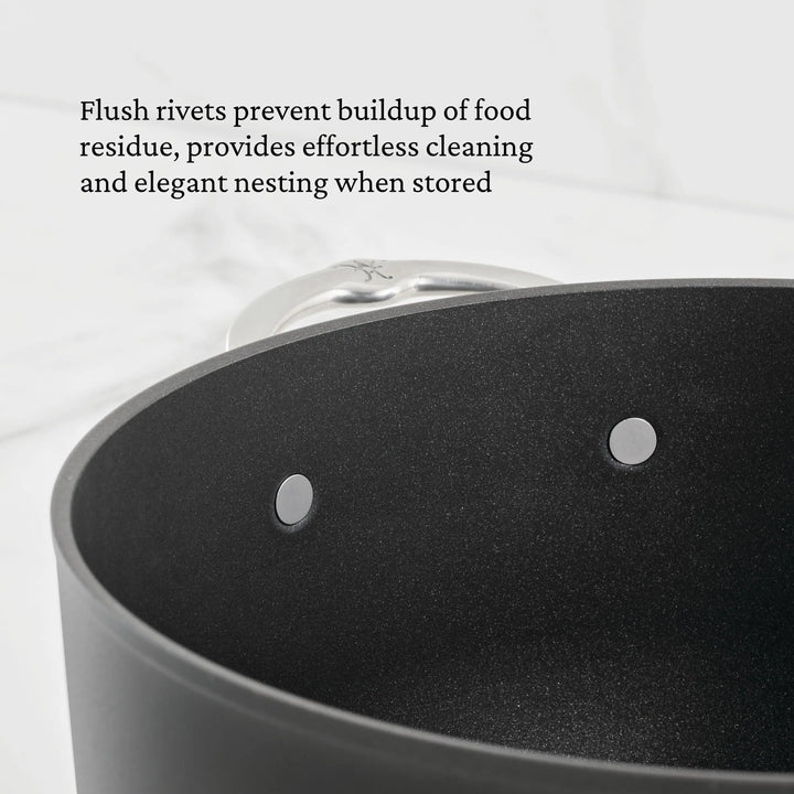 A close-up of the TITUM® Fusion TITUM Nonstick Essential Pan with Lid, 4.5-Quart highlights two flush metal rivets inside, emphasizing their easy-to-clean design and improved storage benefits.