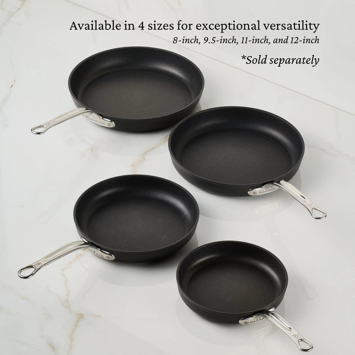Four TITUM® Fusion TITUM Nonstick Open Skillets (8", 9.5", 11", and 12"), each with a metal handle, are arranged on white marble. Text notes sizes and that skillets are sold separately.