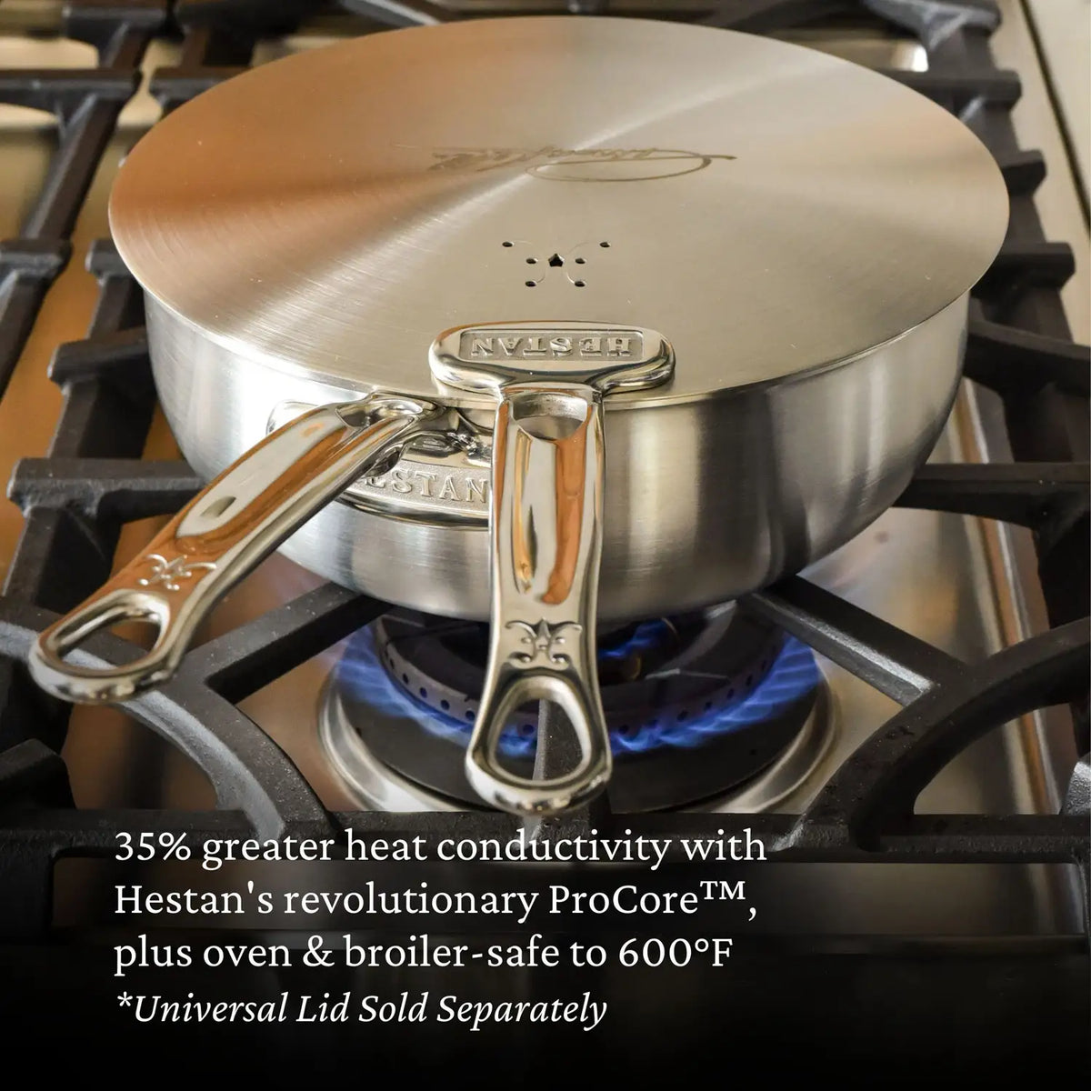 A Thomas Keller Commercial Clad Stainless Steel 2-Quart Saucier sits on a gas burner, offering pro-level cooking with 35% more heat conductivity. The tri-ply cookware is safe in oven and broiler up to 600°F; universal lid sold separately.