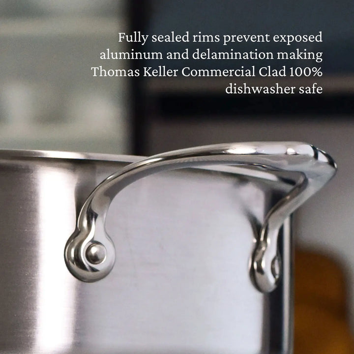 A close-up of the polished stainless steel pot handle showcases its smooth finish. Above, text declares: Fully sealed rims prevent exposed ProCore aluminum and delamination, ensuring the Thomas Keller Insignia Commercial Clad Stainless Steel 7-Piece Cookware Set is 100% dishwasher safe.