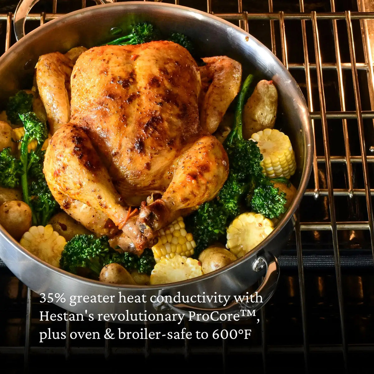 A whole roasted chicken with broccoli, corn, and potatoes sits on an oven rack in a Thomas Keller Commercial Clad Stainless Steel Rondeau, featuring tri-ply construction and safe up to 600°F. ProCore technology is mentioned as well.