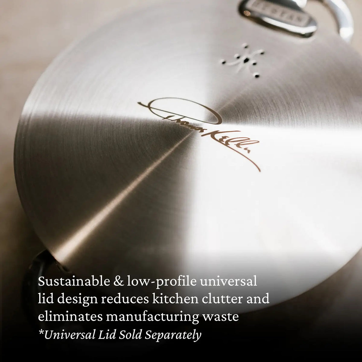A close-up of a brushed metal lid engraved with the Thomas Keller Commercial Clad signature. Text overlay notes the sustainable, low-profile design—ideal for any pro kitchen. The universal lid is sold separately from the Stainless Steel 7-Piece Cookware Set.
