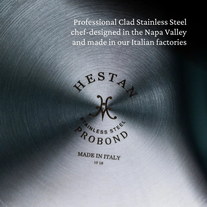 Close-up of the base of a ProBond Professional Clad stainless steel cookware piece reads, Hestan Stainless Steel ProBond Made in Italy, emphasizing its tri-ply design from Napa Valley. Part of the Professional Clad Stainless Steel Ultimate 10-piece Set.