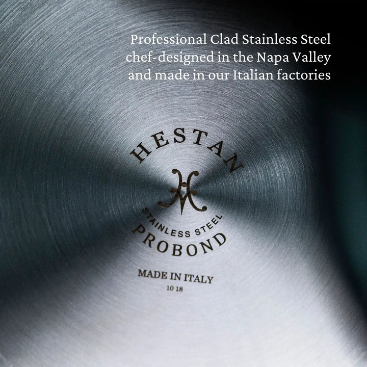 Close-up of the base of a ProBond Professional Clad Stainless Steel Saucepan, highlighting its brushed metal texture. Text reads: Tri-ply aluminum core cookware, chef-designed in Napa Valley and crafted in Italian factories. Made in Italy.