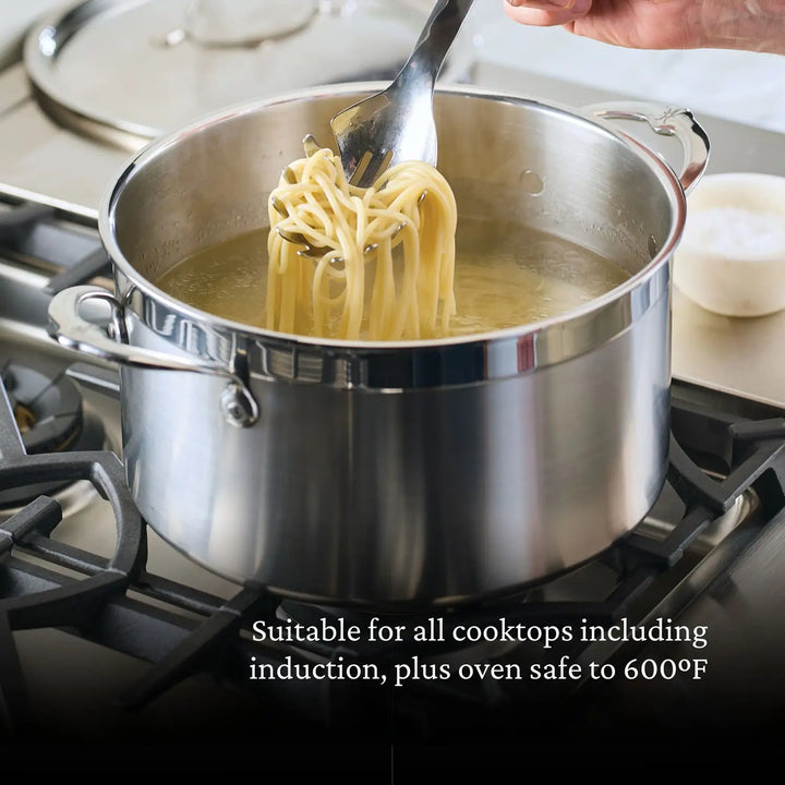 An 8-quart Professional Clad Stainless Steel Stockpot from ProBond sits on a stove with boiling pasta, while a hand uses tongs to lift some out. Text below states, Works with all cooktops, including induction; oven safe up to 600°F.