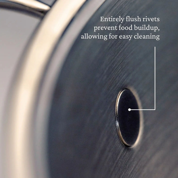 Close-up of a flush rivet on ProBonds Professional Clad Stainless Steel Stockpot, 8-Quart: Completely flush rivets prevent food buildup for easy cleaning. The pots smooth metallic surface gleams brilliantly.