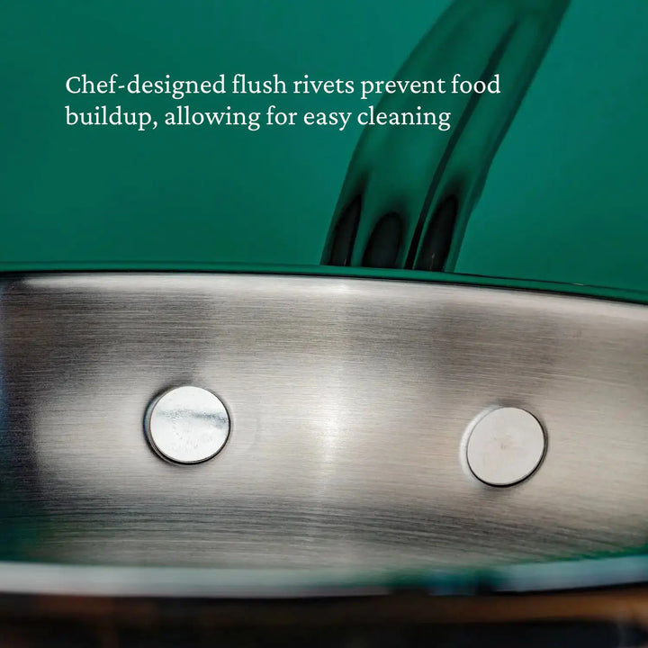 Close-up of a ProBond Professional Clad Stainless Steel Skillet featuring ergonomic handles and flush rivets against a green backdrop. Text above reads, Chef-designed flush rivets prevent food buildup for easy cleaning.