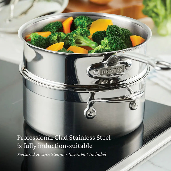 A ProBond Professional Clad Stainless Steel 3-Quart Soup Pot with a tri-ply body and steamer insert is on an induction cooktop, cooking broccoli and sliced carrots. The text reads: Fully induction-suitable; Hestan Steamer Insert not included.