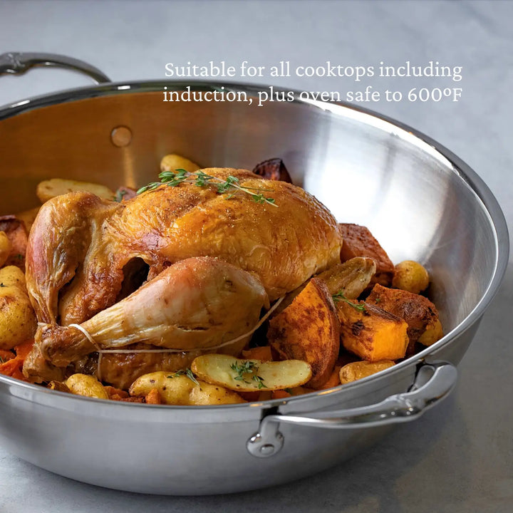 A roasted chicken with vegetables, like potatoes and carrots, is in a large ProBond Professional Clad Stainless Steel Wok, 14-Inch. Text reads: Suitable for all cooktops including induction, plus oven safe to 600°F.