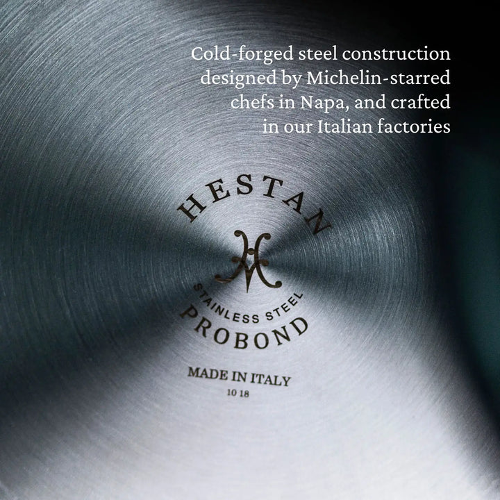 The close-up of a ProBond Professional Clad Stainless Steel TITUM® Nonstick Sauté Pan with Lid, 3.5-Quart shows the base text, ProBond Stainless Steel Made in Italy, showcasing its elegant yet practical design by Michelin-starred chefs and Italian craftsmanship.