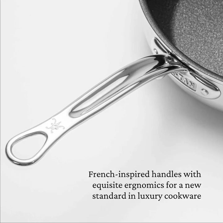 A stainless steel handle with an engraved design, attached to the 3.5-Quart ProBond Professional Clad TITUM® Nonstick Sauté Pan with Lid, showcases a French-inspired ergonomic design emblematic of luxury cookware.