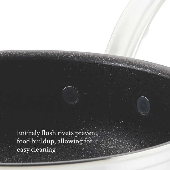 Close-up of a ProBond Professional Clad Stainless Steel TITUM® Nonstick Essential Pan interior with flush rivets, featuring the text: Flush rivets stop food buildup for easy cleaning.