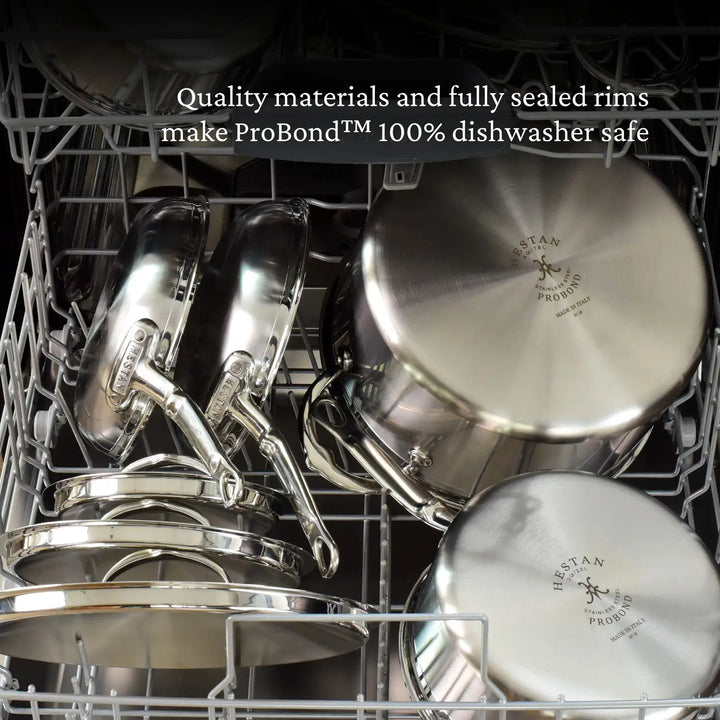 The dishwasher is loaded with ProBond Professional Clad Stainless Steel TITUM® Nonstick Essential Pans and lidded pots, noted for quality materials and fully sealed rims, ensuring they are 100% dishwasher safe.