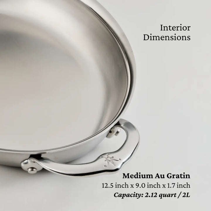 A close-up of a stainless steel medium au gratin pan from the NanoBond Titanium x Tyler Florence Cookware Set, 41-Piece shows its handle. Text displays interior dimensions of 12.5 x 9.0 x 1.7 in and a capacity of 2.12 qt or 2L.