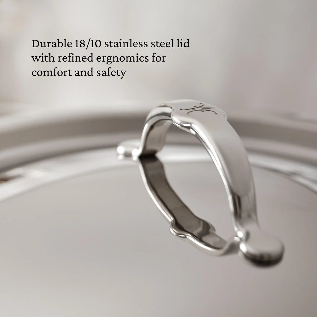 Close-up of the ProBond® Luxe™ Polished Clad Stainless Steel Stockpot lid, featuring a curved handle. Image text: Durable 18/10 stainless steel lid—crafted for comfort, safety, and professional Italian-quality cookware.