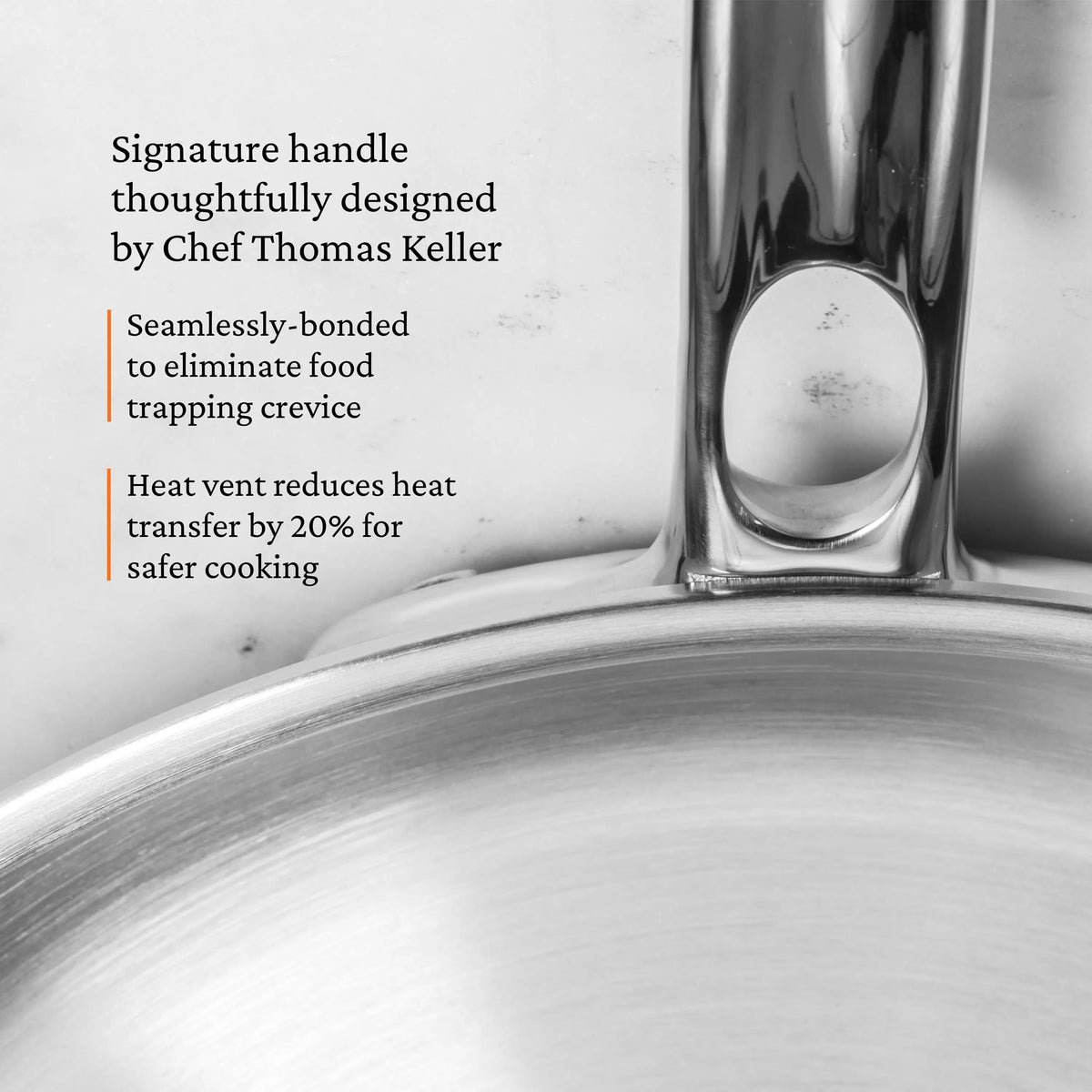 Close-up of the ProBond® Luxe™ Polished Clad Stainless Steel Skillets handle, featuring seamless bonding to prevent food traps and a heat vent that reduces heat transfer by 20%. Designed in collaboration with Chef Thomas Keller.
