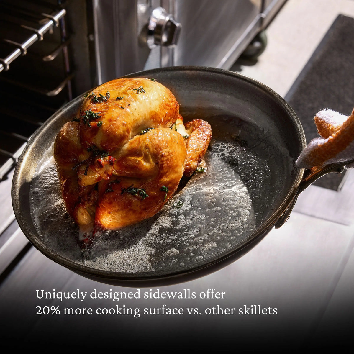 A roasted chicken in a skillet is being taken out of the oven. ProBond® Luxe™ Polished Clad Stainless Steel Skillets offer 20% more cooking surface with uniquely designed sidewalls. Text on image highlights this advantage.