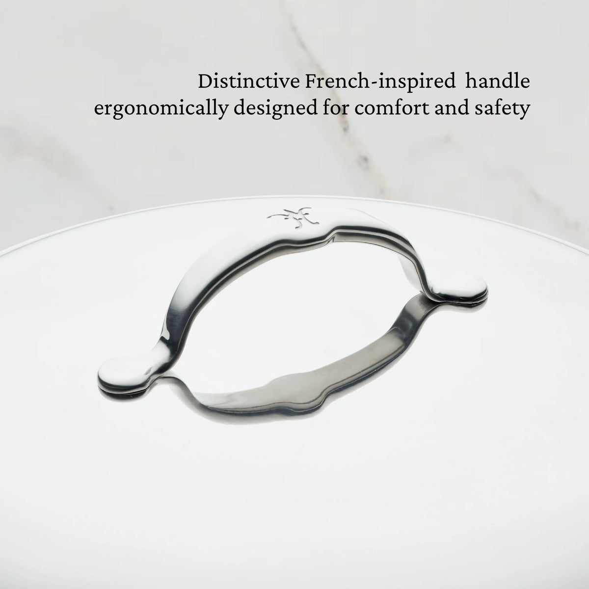 A close-up of ProBond® Luxe™ Polished Clad Stainless Steel Wok with Dome Lid, 14-Inch, shows its French-inspired ergonomic handle. Black text above reads: Distinctive French-inspired handle ergonomically designed for comfort and safety.