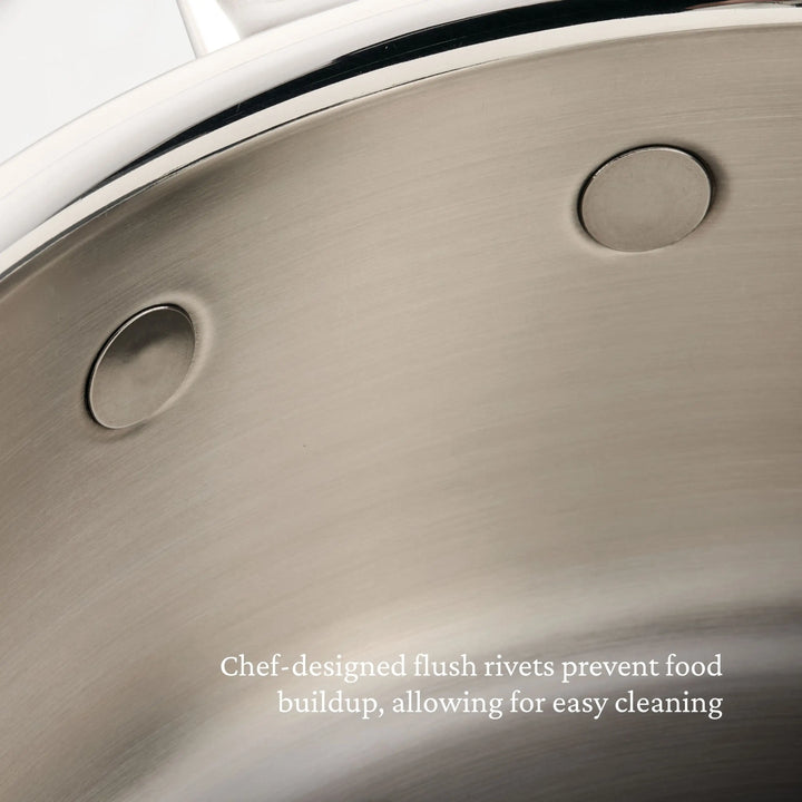 Close-up view of the interior of the ProBond® Luxe™ Polished Clad Stainless Steel Soup Pot with Lid, showing smooth, flush rivets. Text reads: Chef-designed flush rivets prevent food buildup for easy cleaning.