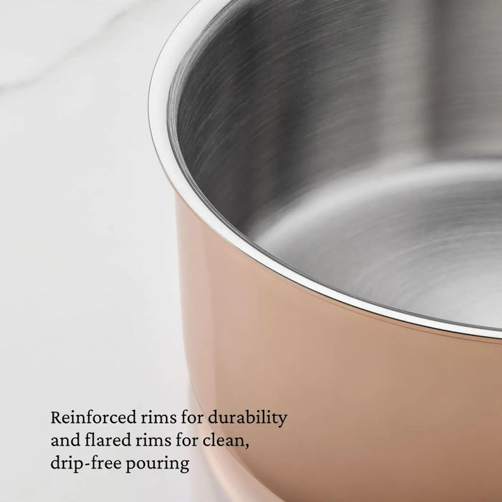 Close-up of the CopperBond® Aura™ Polished Copper Saucepans with Lid, showcasing a copper-colored exterior, reinforced rims for enhanced durability, and slightly flared edges. Combining the elegance and performance of premium copper cookware, these saucepans also feature a stainless steel interior for effortless cleaning. Text reads: Reinforced rims for durability and flared rims for clean, drip-free pouring.