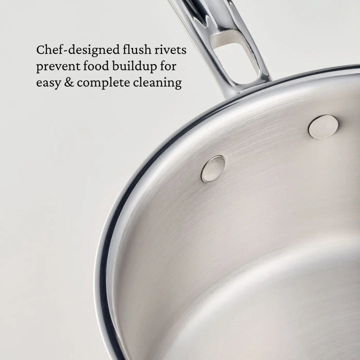 Close-up of the CopperBond® Aura™ Polished Copper 2-Quart Saucier with Lid, featuring chef-designed flush rivets on the stainless steel interior that prevent food buildup for easy & thorough cleaning. Crafted as part of our professional chef cookware collection, this saucier delivers top-tier performance in any kitchen. The handle is partially visible at the top.
