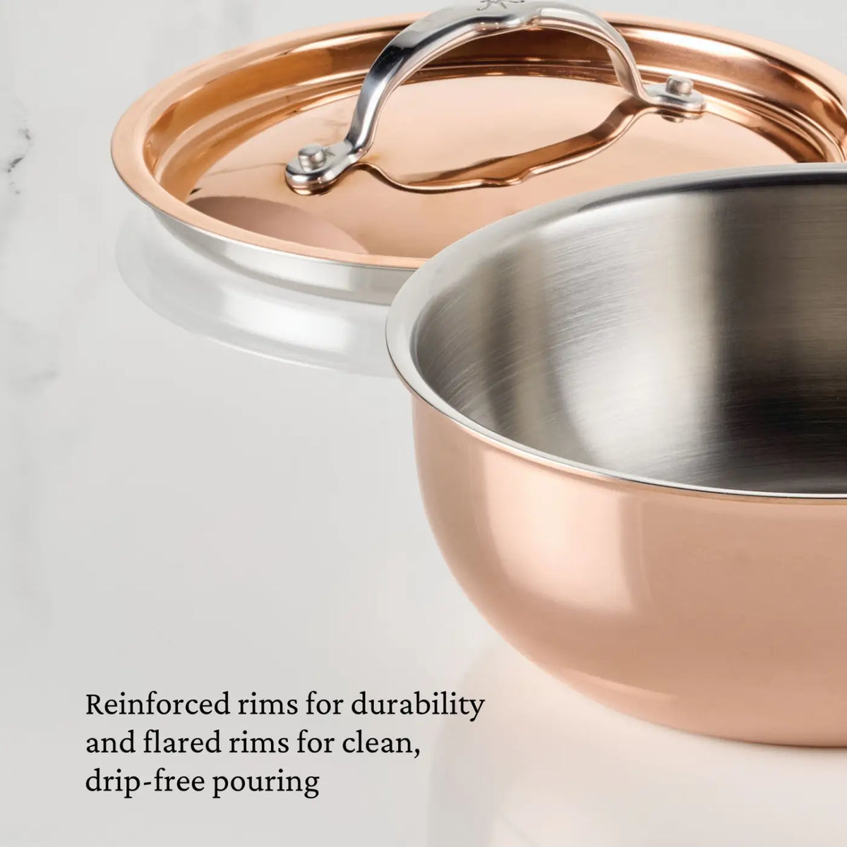 Close-up of the Polished Copper 2-Quart Saucier with Lid from CopperBond® Aura™, shown on a marble surface. Reinforced rims add durability, while flared edges ensure clean, drip-free pouring—distinctive features of Italian-made cookware admired by professional chefs and cooking enthusiasts alike.