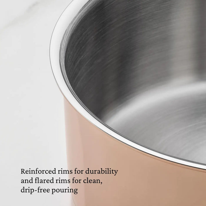 Close-up of a CopperBond® Aura™ Polished Copper Stock Pot with Lid, showcasing its gleaming, flared rim. The image highlights reinforced rims for enhanced durability and drip-free pouring, along with a brushed copper exterior and stainless steel interior—blending elegance with long-lasting performance.