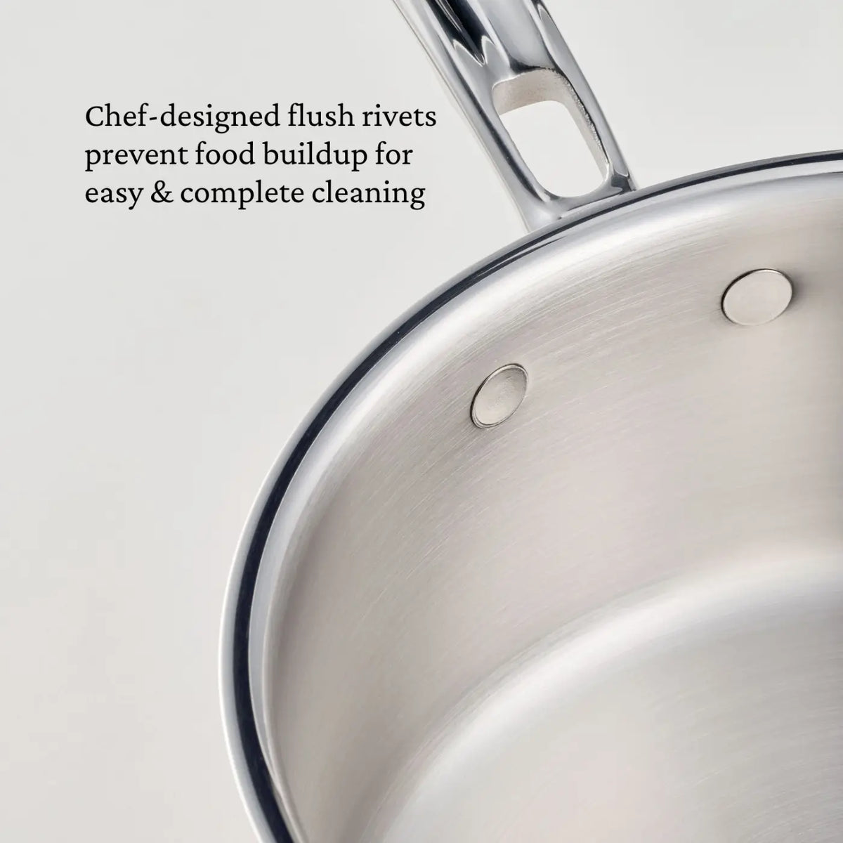 Close-up of a CopperBond® Aura™ Polished Copper Saute Pan with Lid, showcasing flush rivets on the stainless steel interior. The handle is partially visible. Text on the image reads: Chef-designed flush rivets prevent food buildup for easy & complete cleaning—a thoughtful detail found in premium Italian copper cookware like the CopperBond® Aura™ Polished Copper Saute Pan with Lid and its durable stainless steel interior.