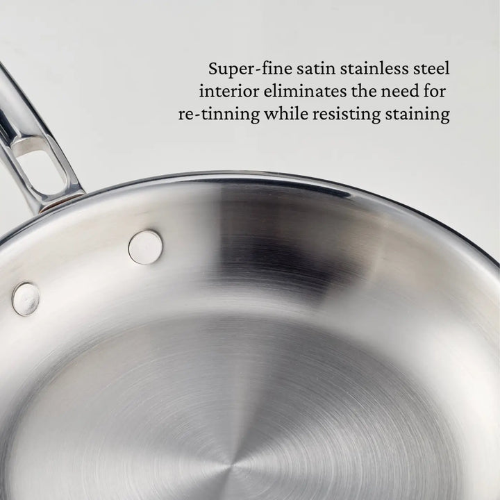 A close-up of a Polished Copper Skillet from CopperBond® Aura™ showcases its super-fine satin stainless steel interior, which resists staining and eliminates the need for re-tinning—delivering professional-grade cookware quality typically found in premium copper skillets.