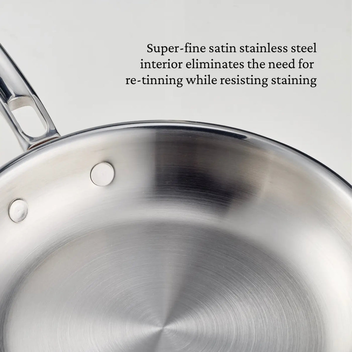 A close-up of a Polished Copper Skillet from CopperBond® Aura™ showcases its super-fine satin stainless steel interior, which resists staining and eliminates the need for re-tinning—delivering professional-grade cookware quality typically found in premium copper skillets.