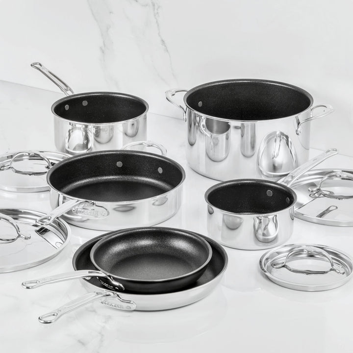 A 10-piece set of ProBond Luxe® Polished Clad Stainless Steel cookware featuring TITUM® nonstick interiors, including an assortment of saucepans, frying pans, and a stockpot—each with its own matching lid—beautifully displayed on a white marble surface.
