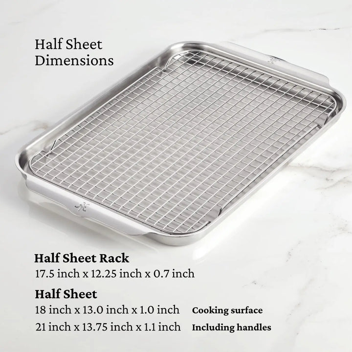 A Hestan Provisions metal baking rack measures 17.5 x 12.25 x 0.7 inches on a half sheet pan (18 x 13 x 1 inches; with handles, its 21 x 13.75 x 1.1 inches) and sits on a marble surface from the OvenBond Tri-ply Set by the same brand.