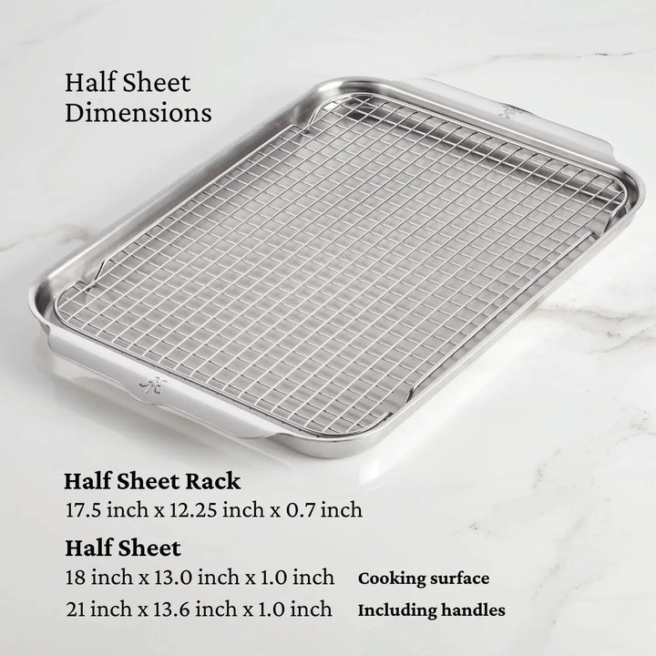 The sleek OvenBond Tri-ply 4-Piece Set by Hestan Provisions, featuring a stainless steel sheet pan and fitted wire rack, rests on a white marble surface. Dimensions: half sheet rack (17.5 x 12.25 x 0.7), pan (18 x 13 x 1), ideal for culinary needs.