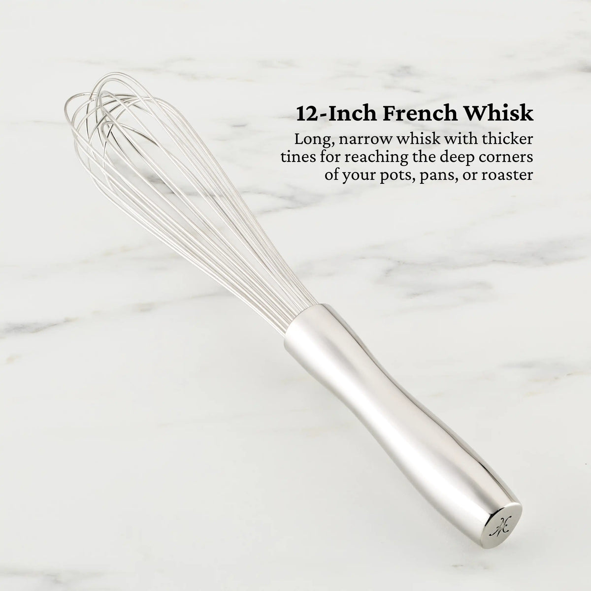 A 12-inch OvenBond whisk by Hestan Provisions, featuring long, narrow stainless steel tines and a bakeware-inspired design with a thicker handle for deep pots, rests on marble.