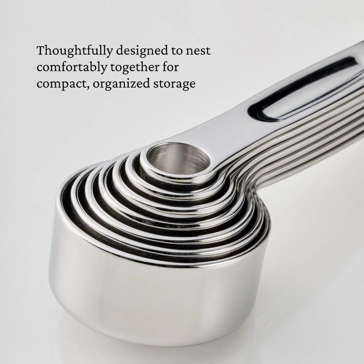 A stack of the Hestan Provisions® Odd-Size Measuring Cups Set, 3-Piece is nested together on a white surface. Text above the cups reads, Thoughtfully designed to nest comfortably together for compact, organized storage—part of the Provisions Chef’s Tools collection.