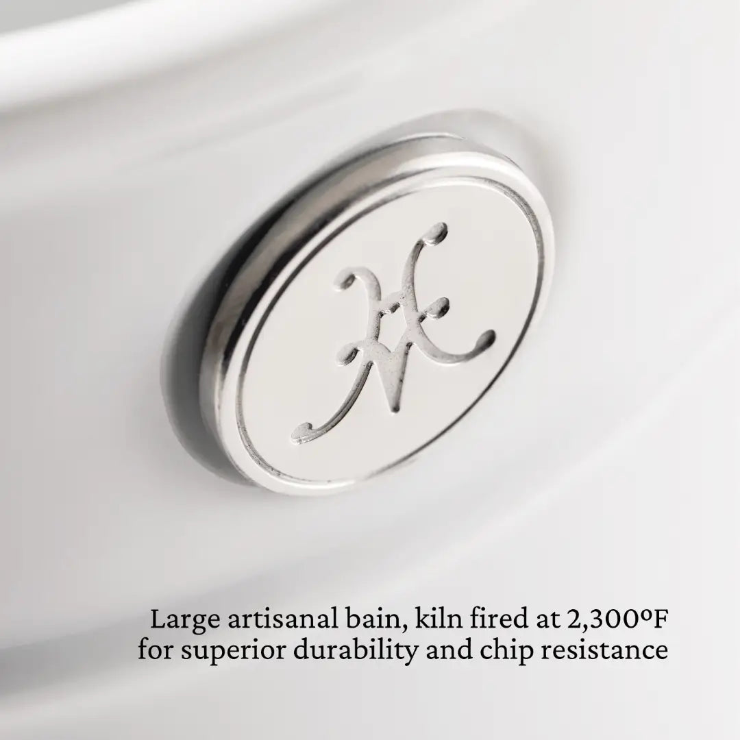 Close-up of a white Porcelain Bain Marie, featuring a circular metal emblem with a decorative letter. Text reads: Kiln fired at 2,300°F for superior durability and chip resistance. Perfect for those who appreciate Hestan Provisions kitchen essentials.