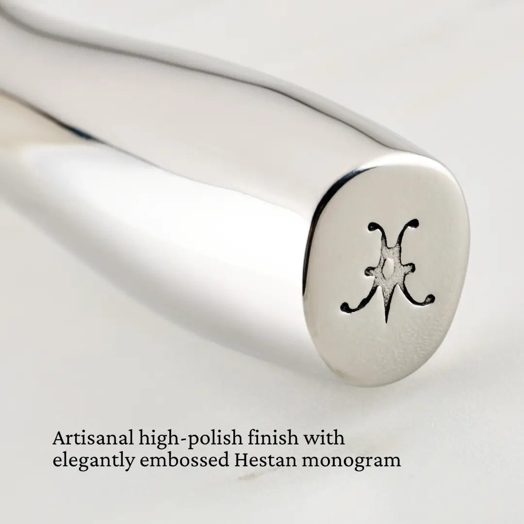 A stainless steel Hestan Provisions French Whisk displays a high-polish finish with an elegantly embossed monogram.