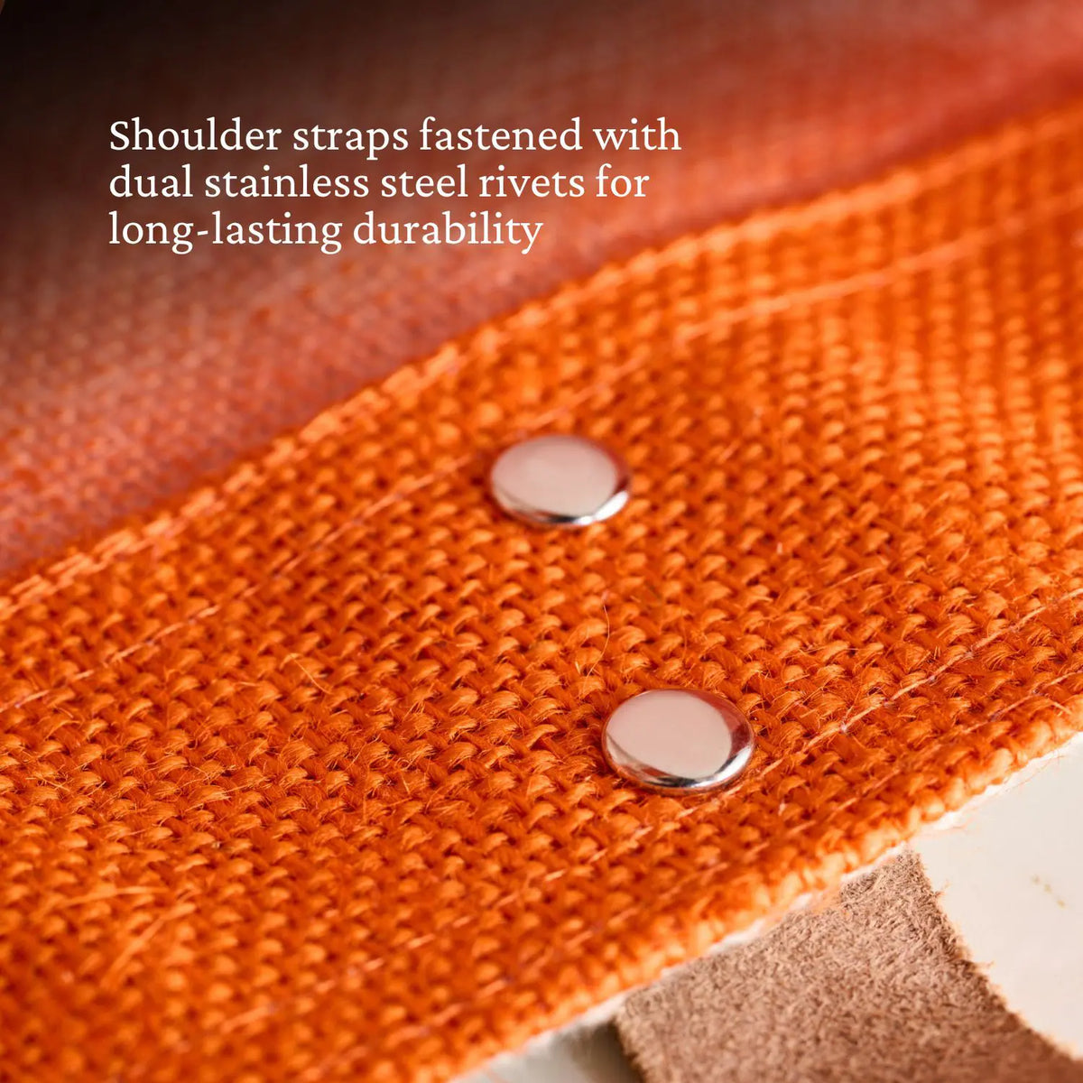 A close-up of Citra Orange fabric on the Accessories Hestan Market Tote features a strap secured by two stainless steel rivets, showcasing durable luxury and long-lasting quality.