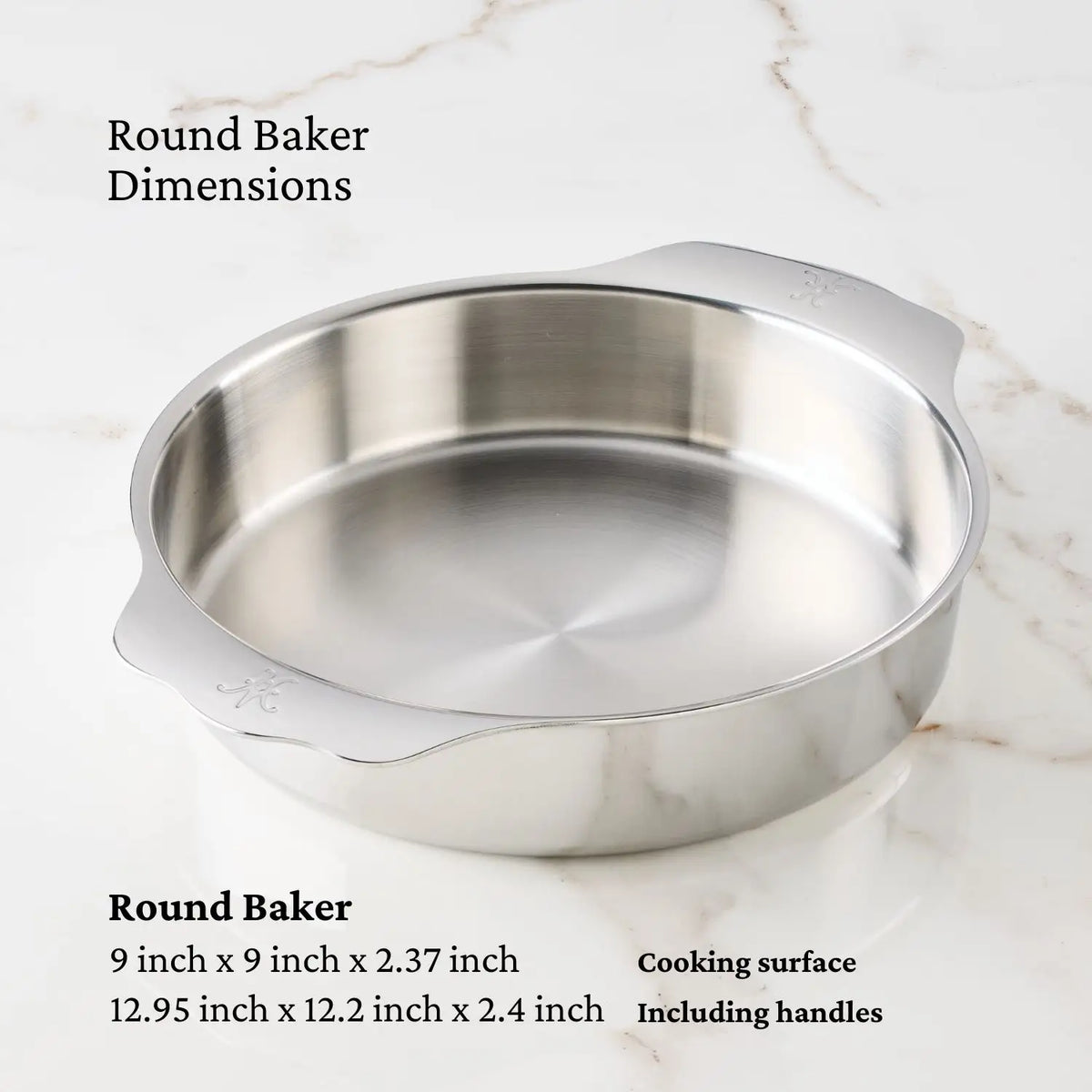 The Hestan Provisions OvenBond Round Baker, 9-inch, a stainless steel pan with handles, sits on a marble surface. Its cooking surface is 9 x 9 x 2.37 in; overall dimensions with handles are 12.95 x 12.2 x 2.4 in.