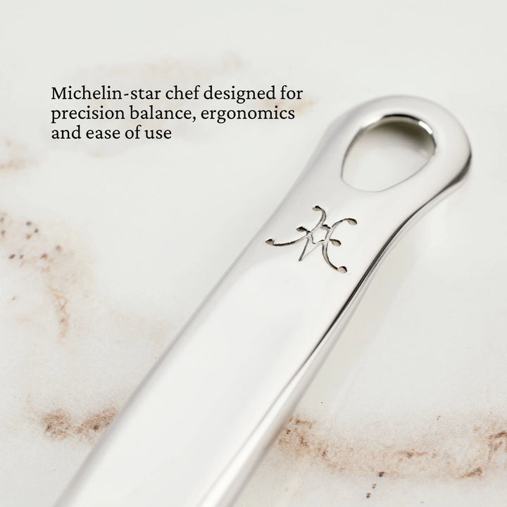 Close-up of a silver Sauté Spoon with Straight Edge, 13-inch by Hestan Provisions, featuring an engraved logo and oval hole. Michelin-star chef designed for precision balance, ergonomics, and ease of use.