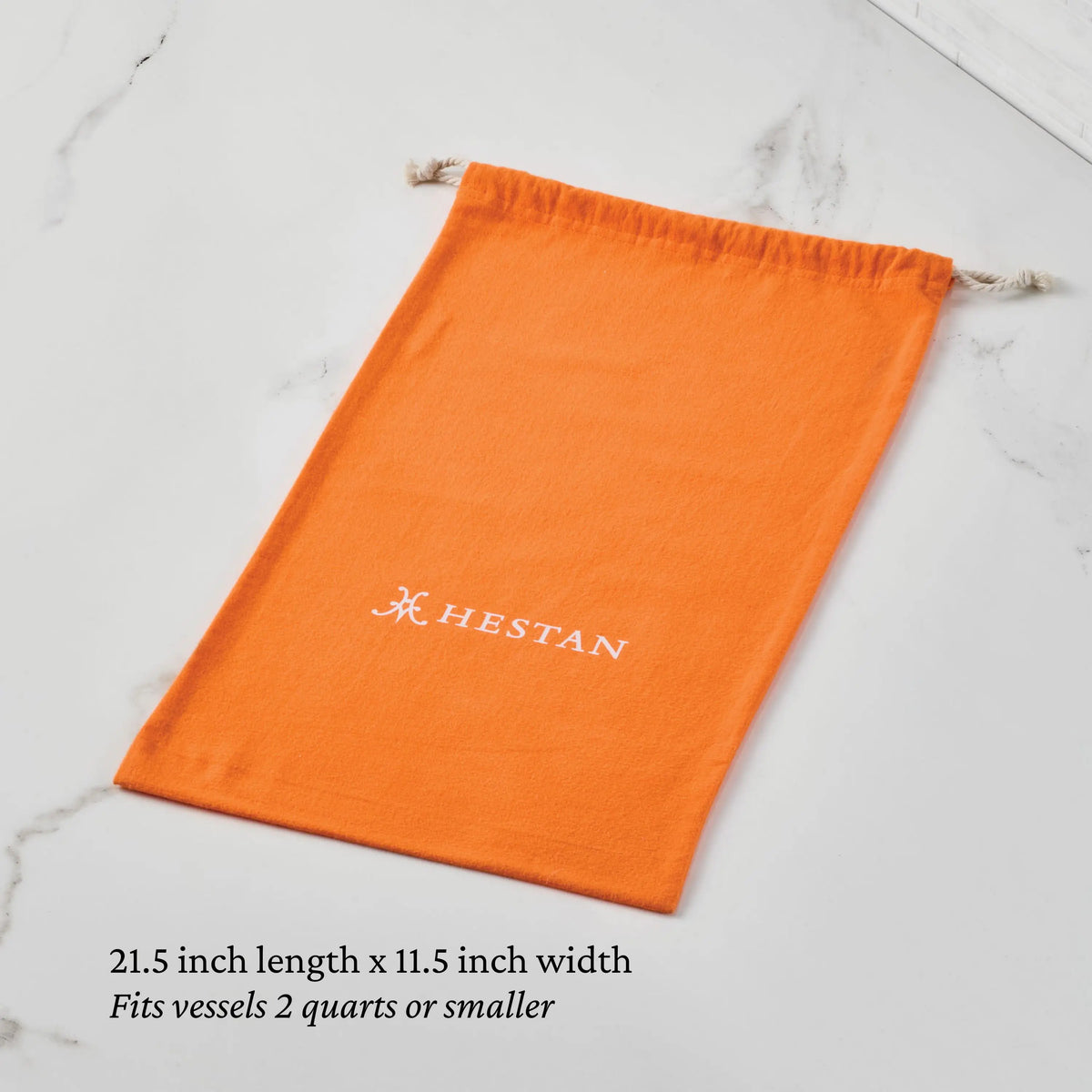 A Flannel Cookware Storage Bag by Accessories lays flat on marble. This orange drawstring bag fits cookware up to 2 quarts, measures 21.5" x 11.5", and is ideal for protecting and storing your kitchen vessels.