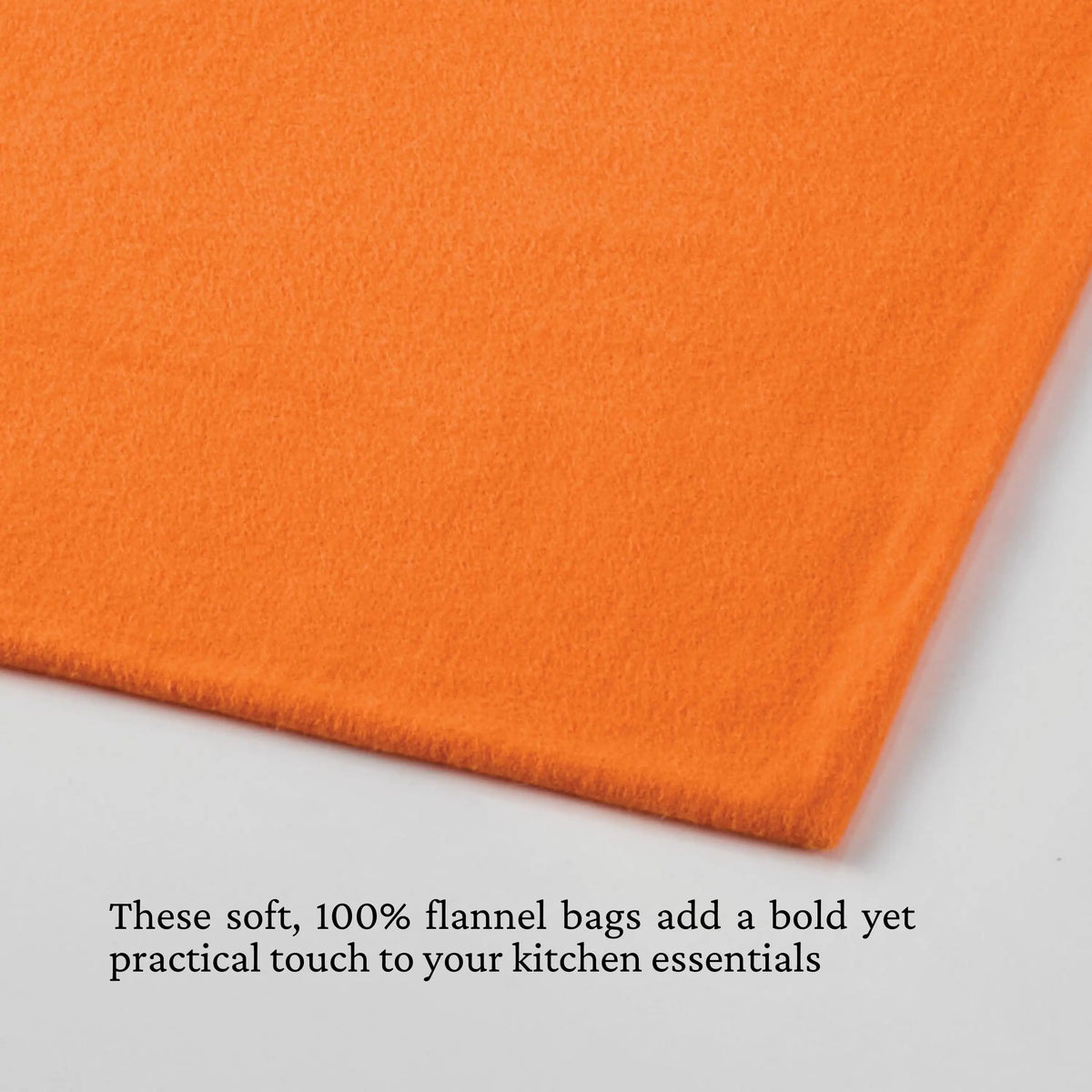 A neatly folded orange flannel rests on a white surface. Below, text highlights Accessories’ Flannel Lid Storage Bags: soft, 100% flannel, boldly colored and designed for practical kitchen use as protective cookware bag solutions.