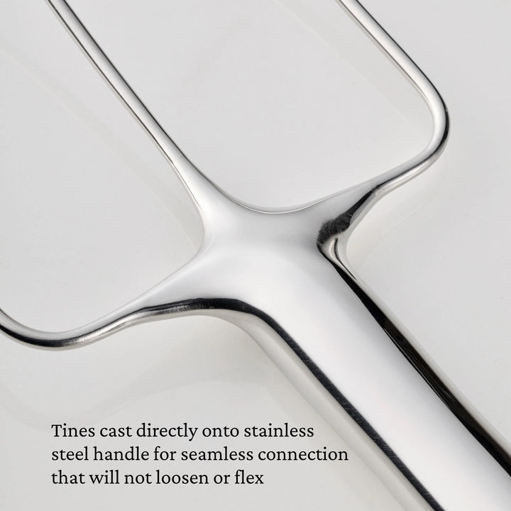 Close-up of a Hestan Provisions® Stainless Steel Carving Fork from the Set of 2, featuring three tines seamlessly cast directly onto the handle. The text highlights this secure, non-flexing connection as a hallmark of professional carving fork durability.