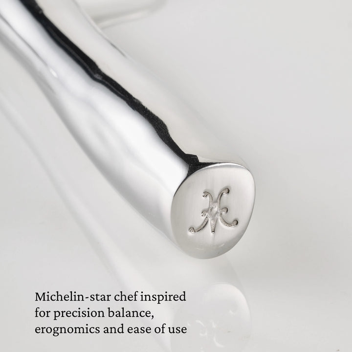 Close-up of a gleaming 18/10 stainless steel handle from a Hestan Provisions® Stainless Steel Carving Fork, Set of 2, finely engraved with a decorative H at the end. Text in the lower left corner reads: Michelin-star chef inspired for precision balance, ergonomics and ease of use—a hallmark of Hestan Provisions® professional carving forks.