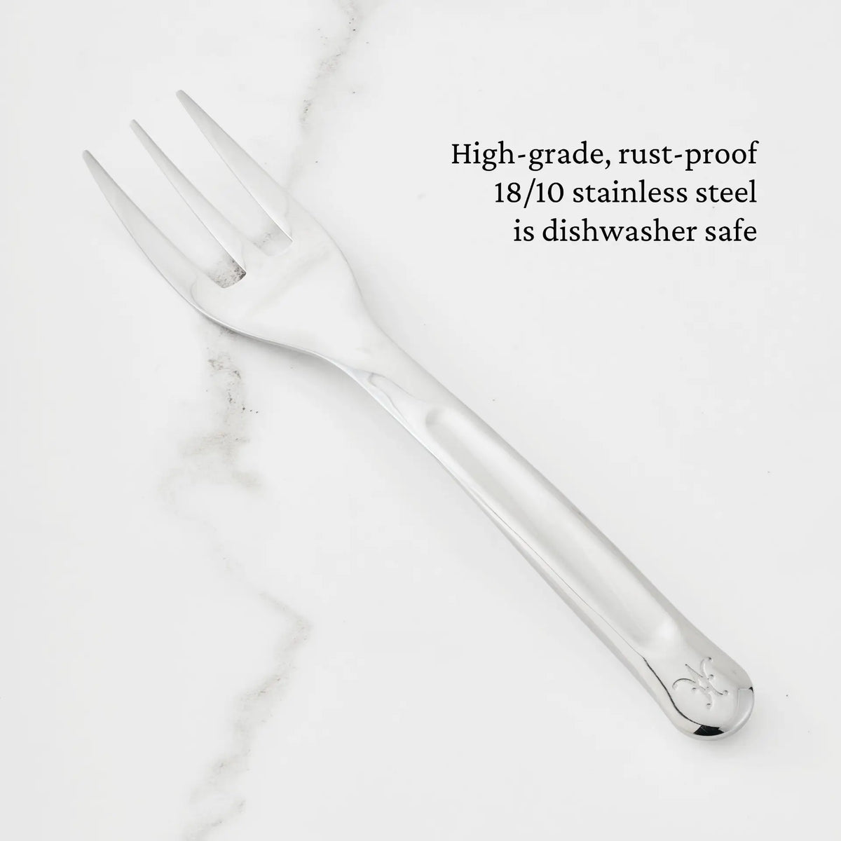 A 10.5-inch Stainless Steel Serving Fork from Hestan Provisions is displayed on a white marble surface. The text highlights that this fork, part of the Hestan Provisions Serving Tools collection, is crafted from high-grade, rust-proof 18/10 stainless steel and is dishwasher safe—making it a reliable choice among chef’s tools.