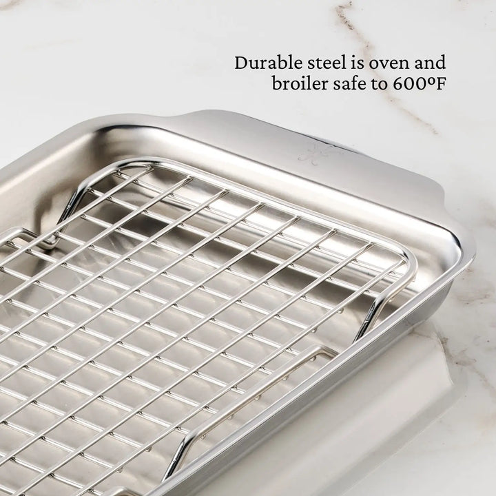 The Hestan Provisions OvenBond Tri-ply Mini Eighth Sheet Pan with Rack, ideal for oven and broiler use up to 600°F, rests on a marble surface. The text highlights its exceptional durability and heat resistance, making it a must-have for culinary enthusiasts.