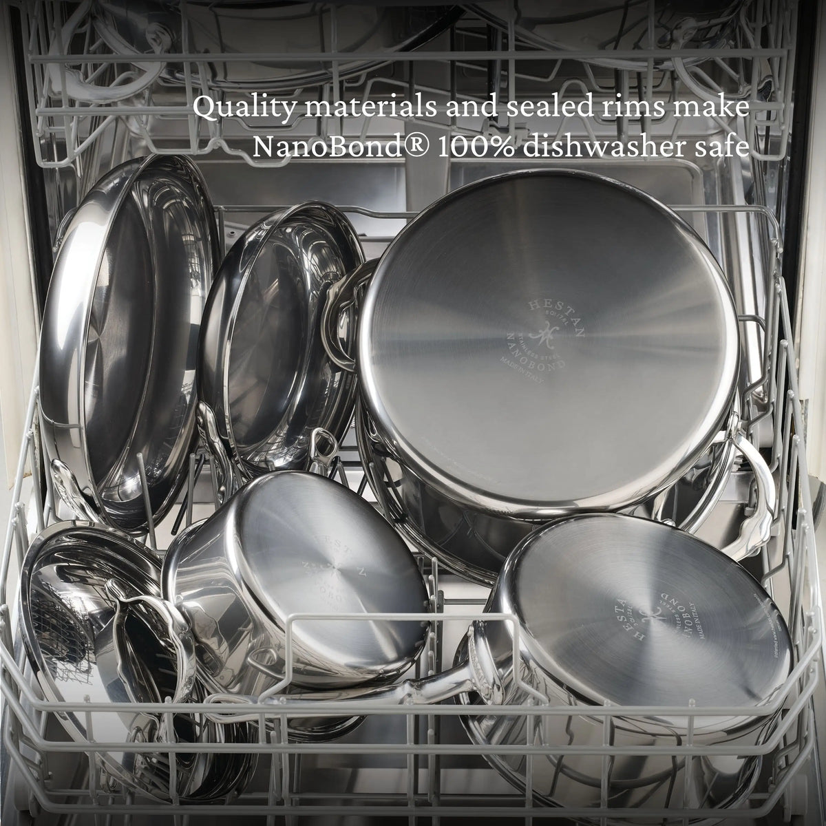 An open dishwasher with clean, shiny NanoBond Titanium Stockpots and pans. Text at the top says: Premium materials and sealed rims make NanoBond® Titanium Stockpots 100% dishwasher safe.