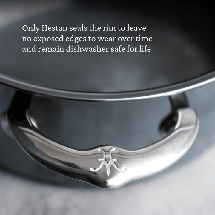 Close-up of a NanoBond Titanium Stockpot handle with engraved logo and part of the rim. Text above notes NanoBond seals the rim to prevent exposed edges, boosting durability and making it dishwasher safe for life.