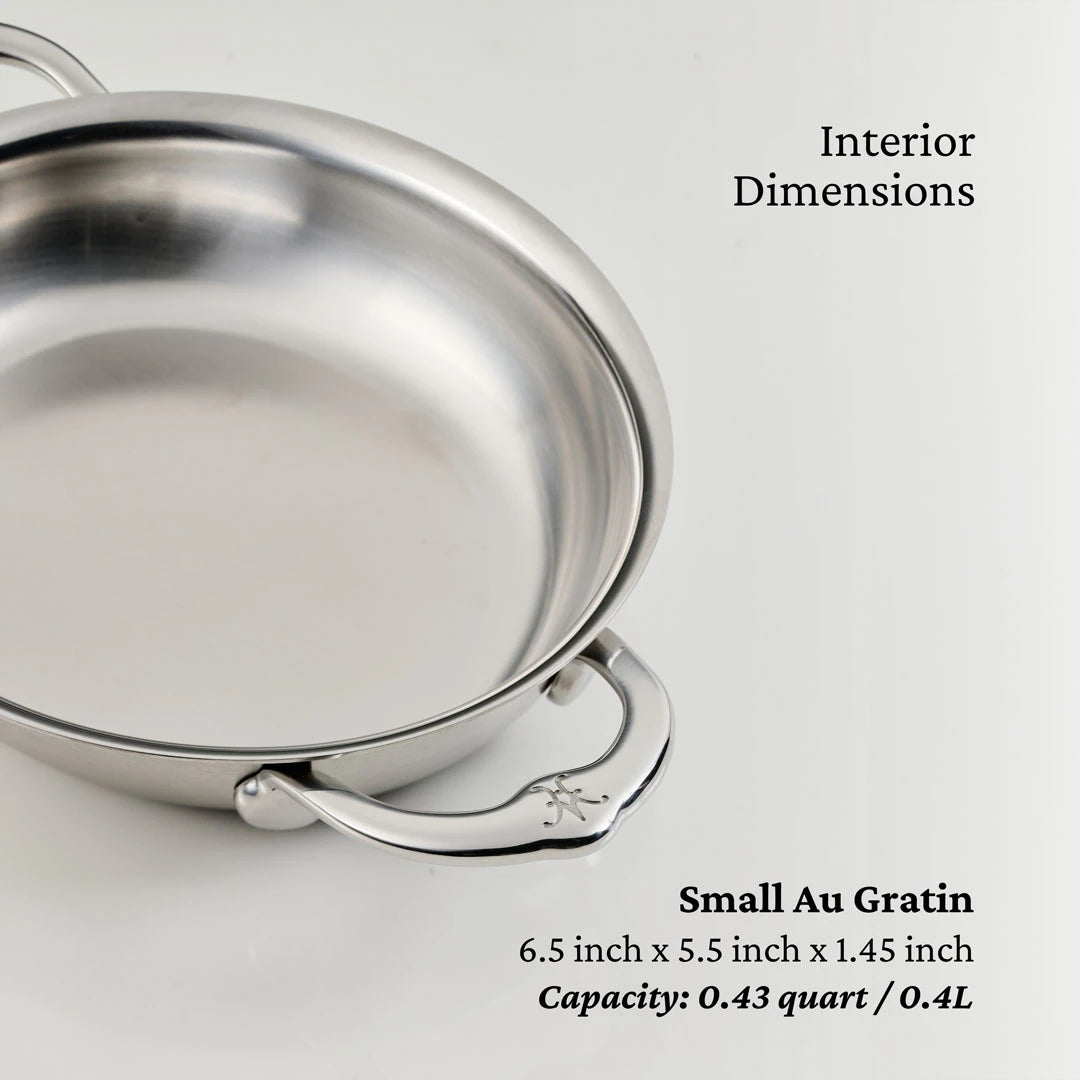 The image shows the Hestan Provisions 6.5-Inch x 5.5-Inch Oval Au Gratin Set (2-piece), featuring two handles, interior dimensions of 6.5 x 5.5 x 1.45 inches, and a capacity of 0.43 quart (0.4L)—perfect for cookware enthusiasts.